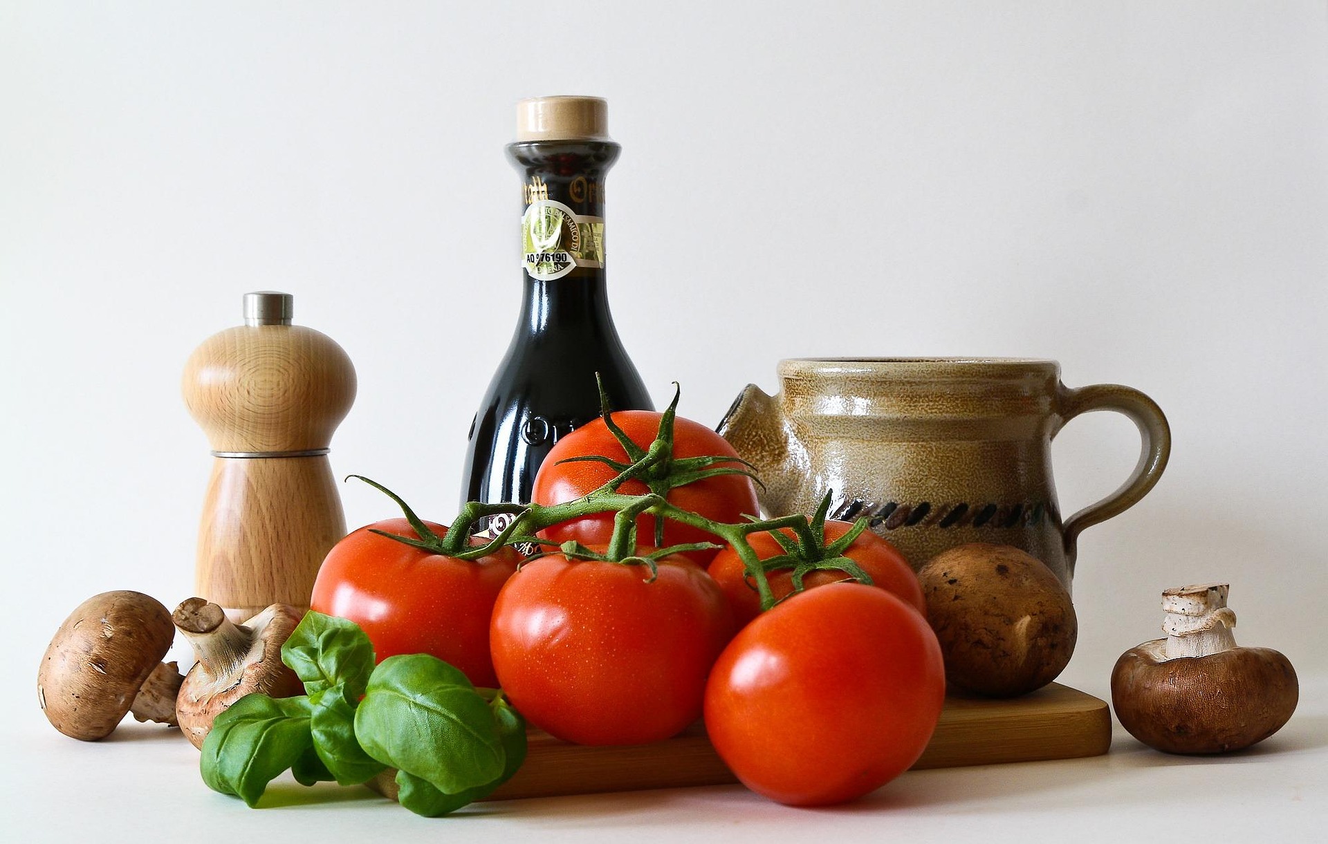 Ingrédients grecs authentiques — huile d'olive, herbes fraîches et olives sur un plan de travail en bois